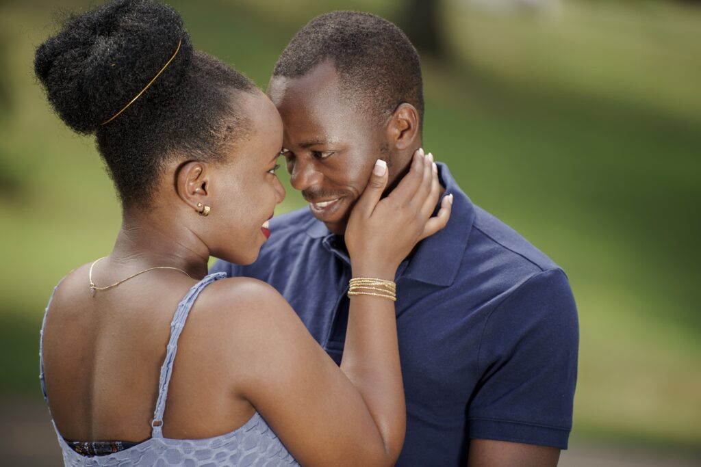 A close portrait of a couple smiling with their foreheads together.