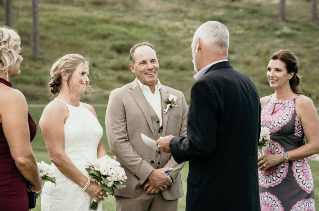 Couple exchanging vows at an outdoor wedding ceremony.