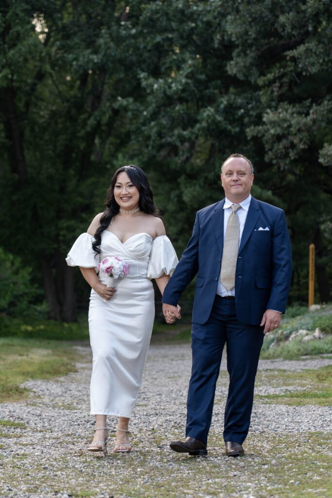Bride and groom standing together on a garden path.